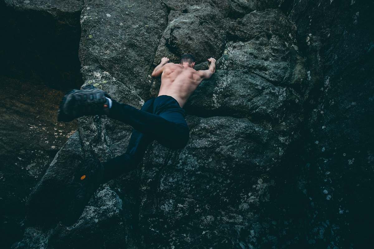 sport man rock climbing on gray rock climb