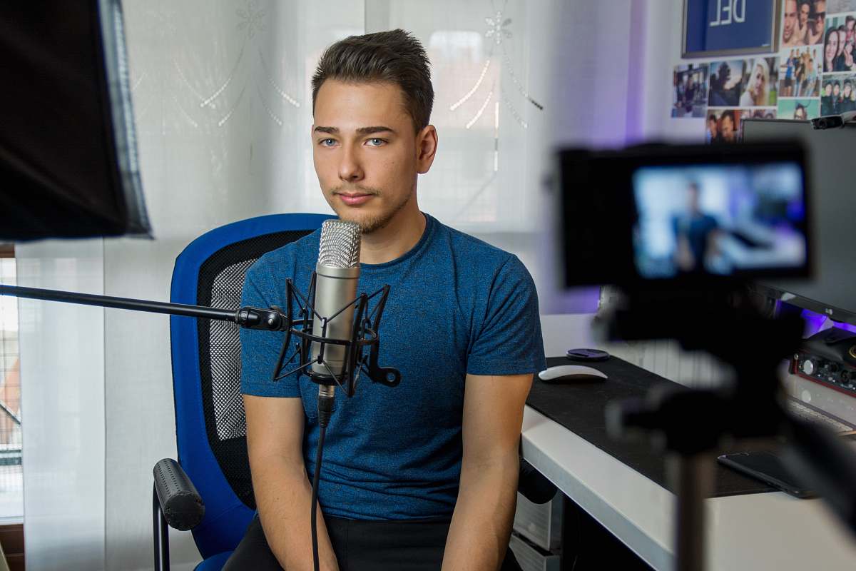 human man sitting on chair in front of condenser microphone people