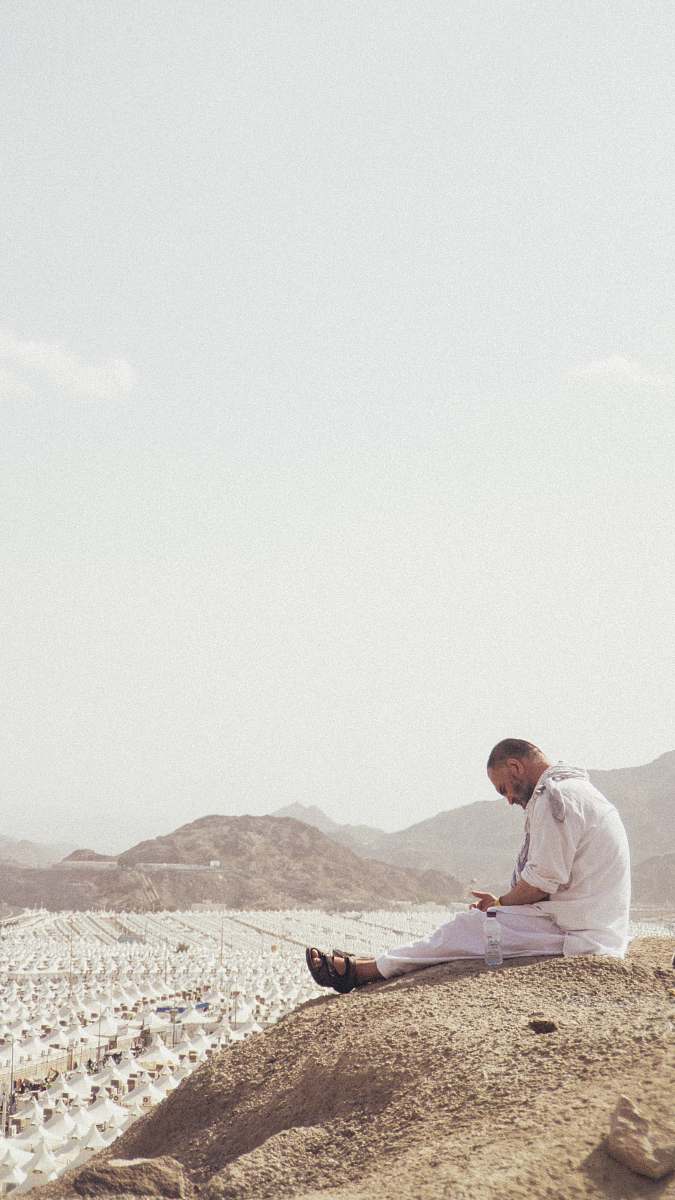 human man sitting on ground near outdoor during daytime sitting