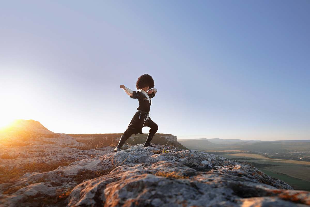 human man standing on peak at daytime outdoors