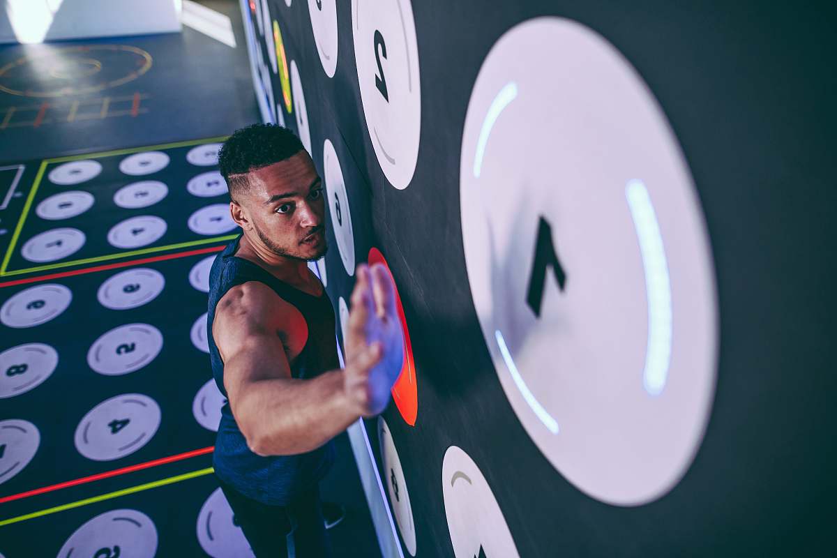human man wearing black tank top climbing and about to reach number 1 sport