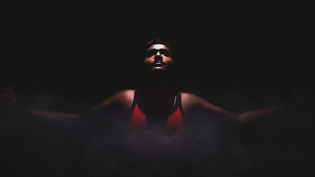 human man wearing red tank top inside dimmed room chennai