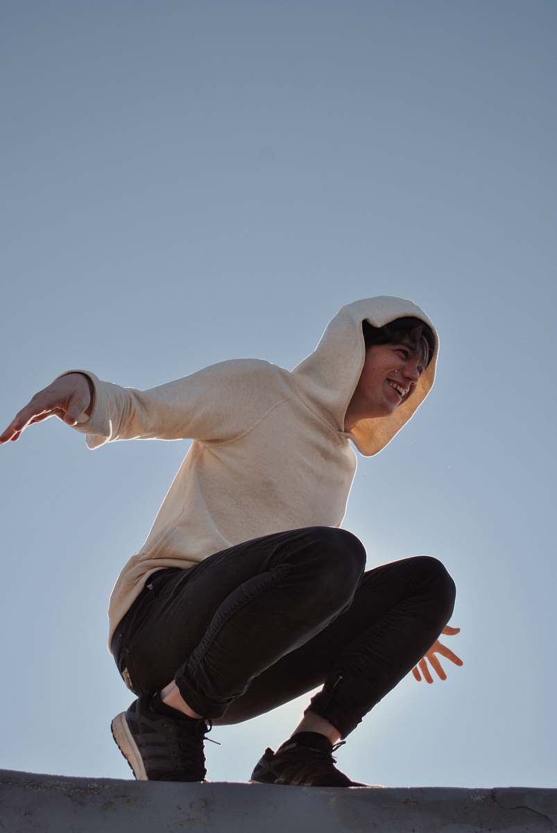 human man wearing white hooded sweater and black pants apparel
