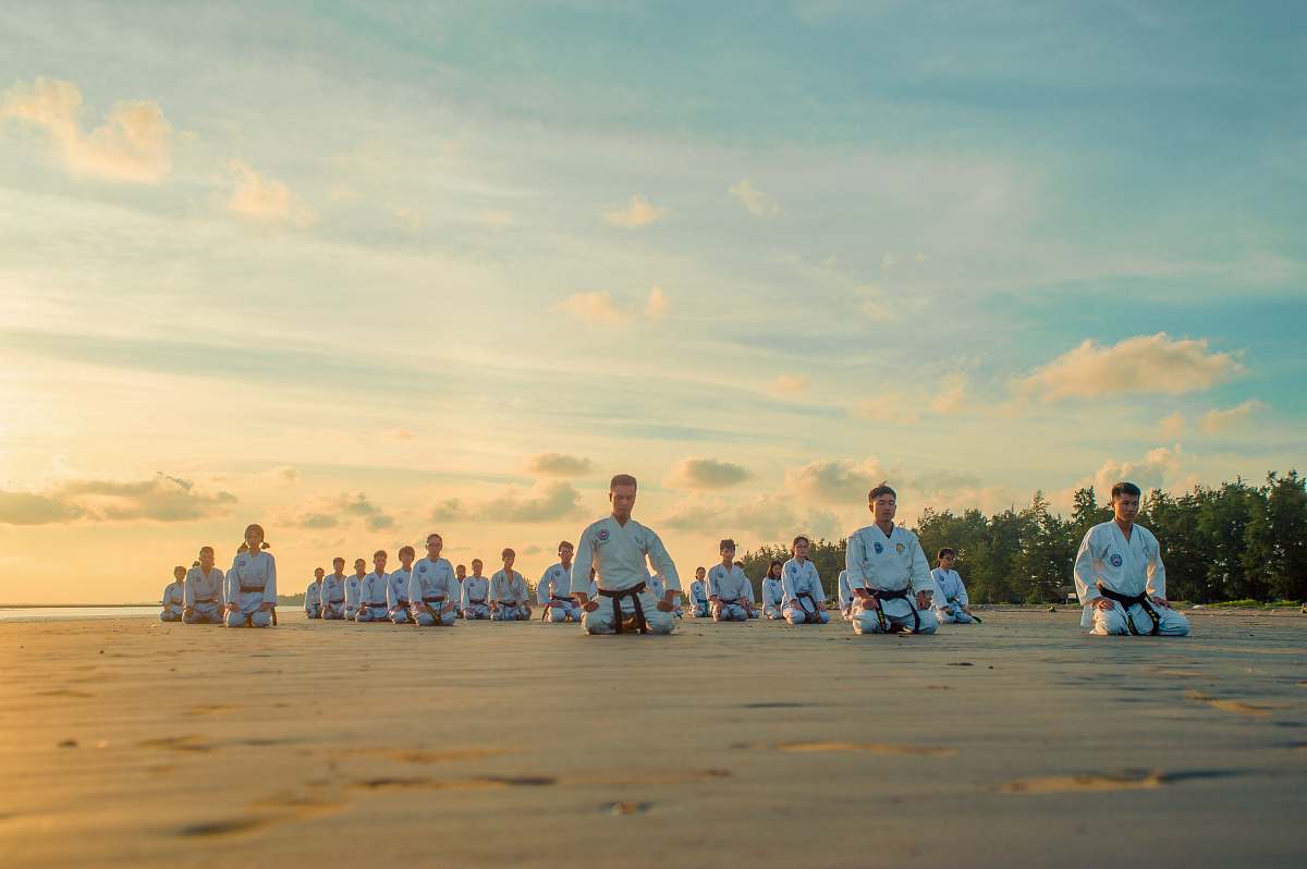 human people kneeling on field during daytime outdoors