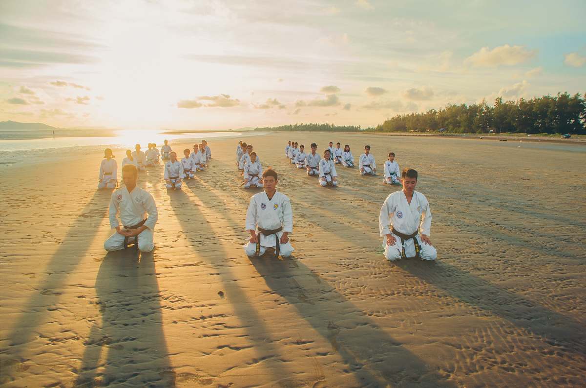 human people kneeling on sandy ground sports