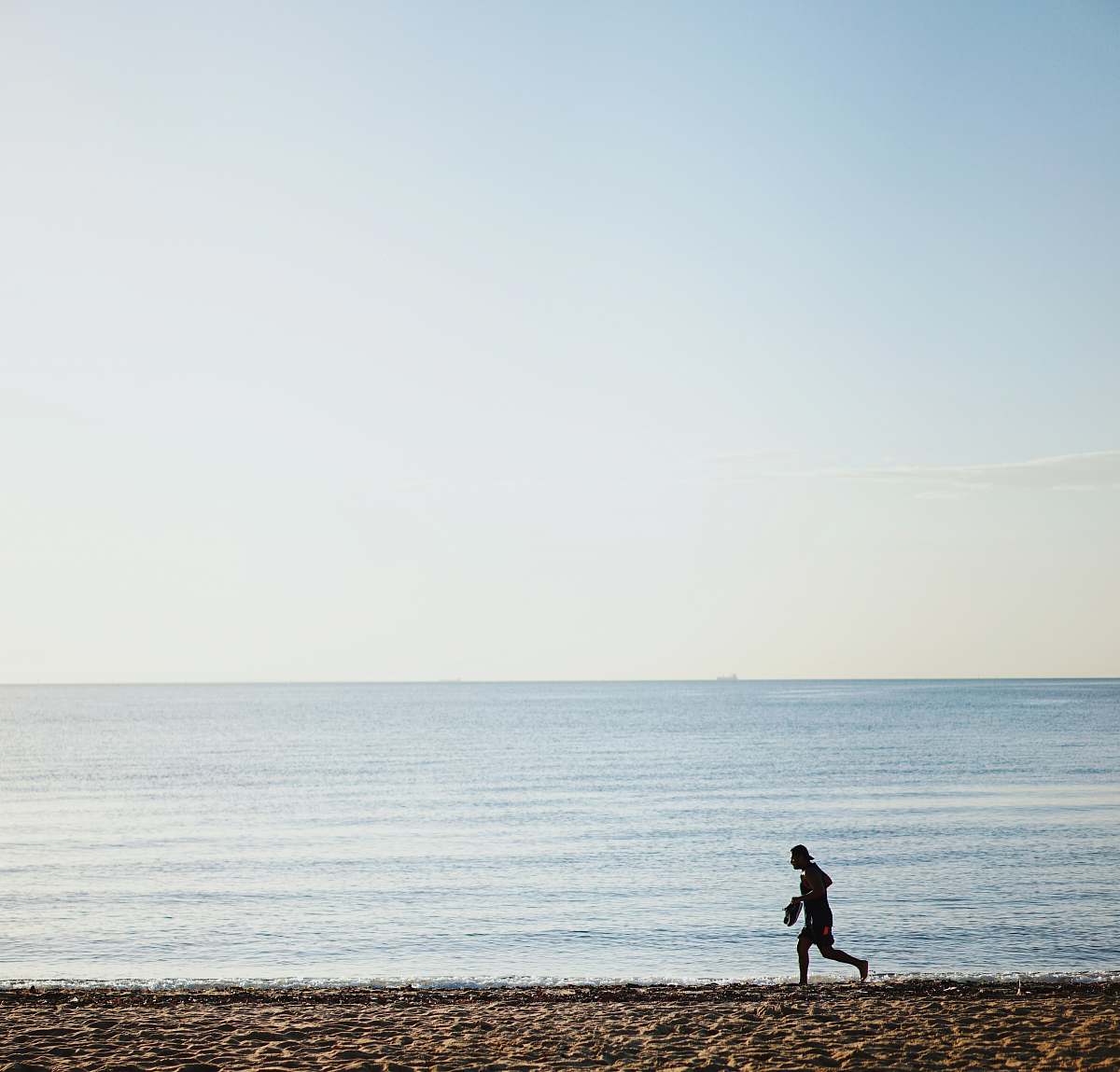 human person running on shore during daytime exercise