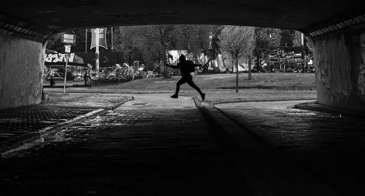 human person running on tunnel black-and-white