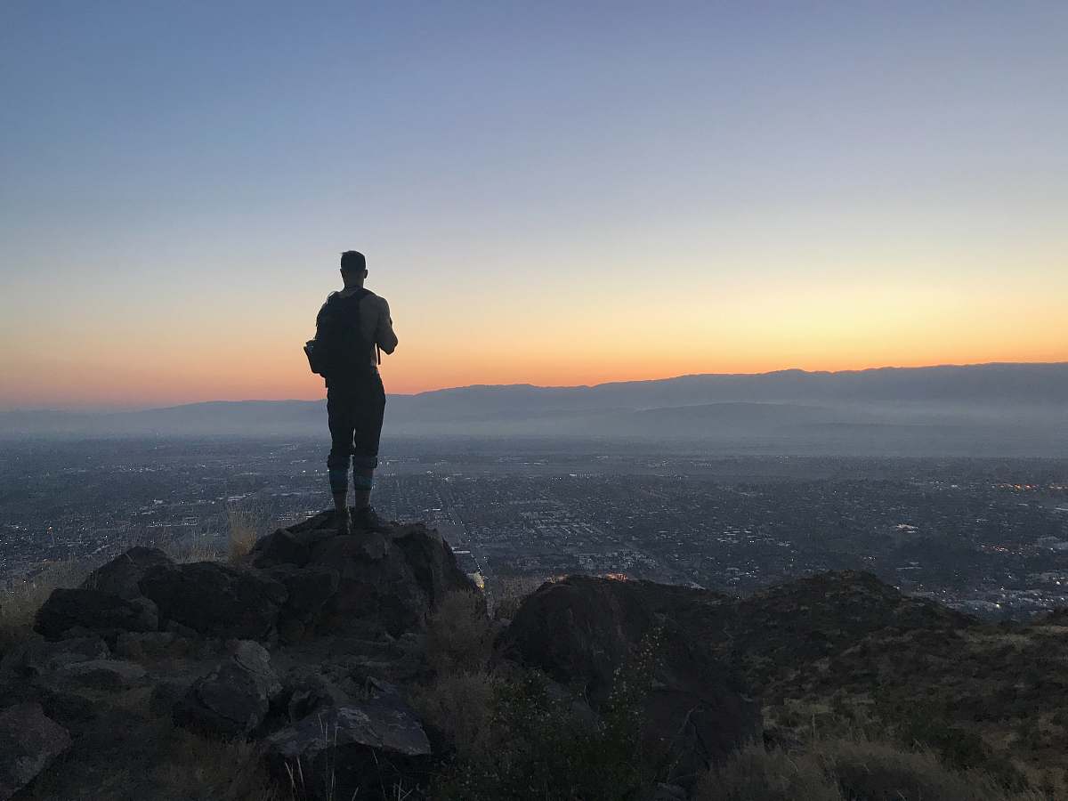 human person standing on gray rock standing