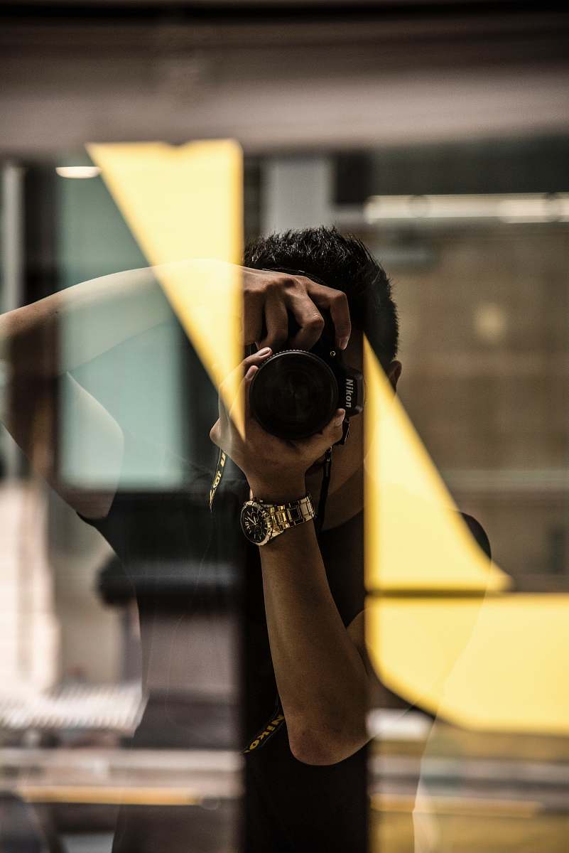 This captivating image showcases a man engaged in the art of self-portrait photography, expertly framing himself within the lens. The scene highlights the creative process of capturing one's identity, making it perfect for articles on photography techniques, self-expression, and social media content. Whether for a blog post or a tutorial on self-portraiture, this image resonates with anyone looking to explore the world of personal photography.