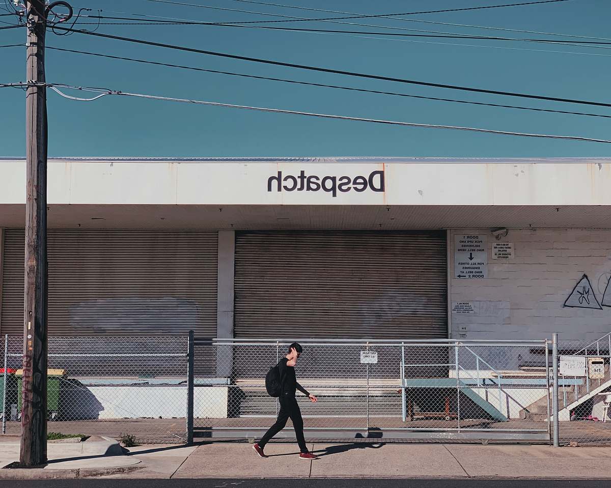 human person walking in front of store grey