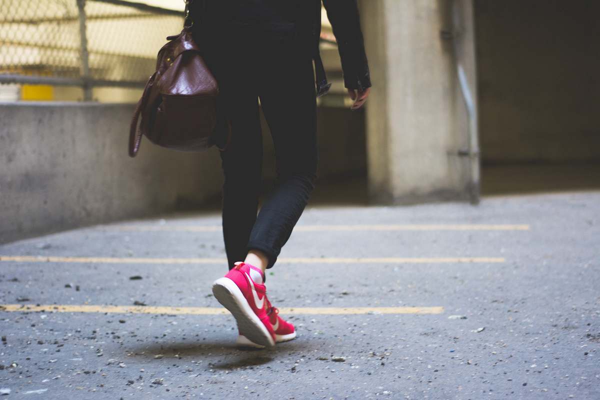 shoe person wearing Nike running shoes walking along the path people