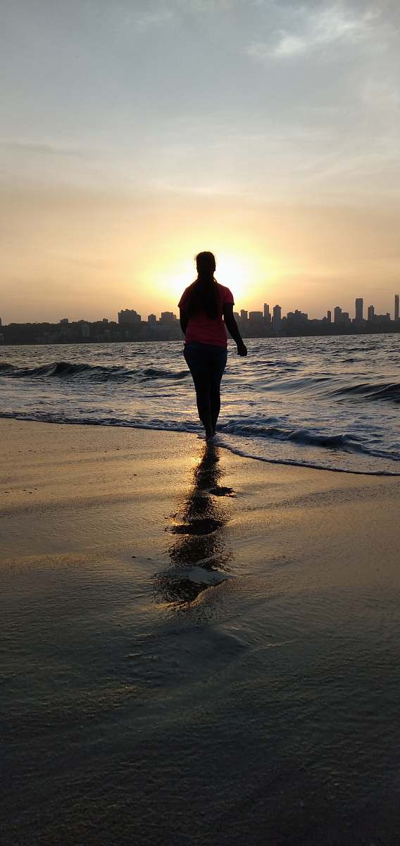 human silhouette of person standing on shore flare