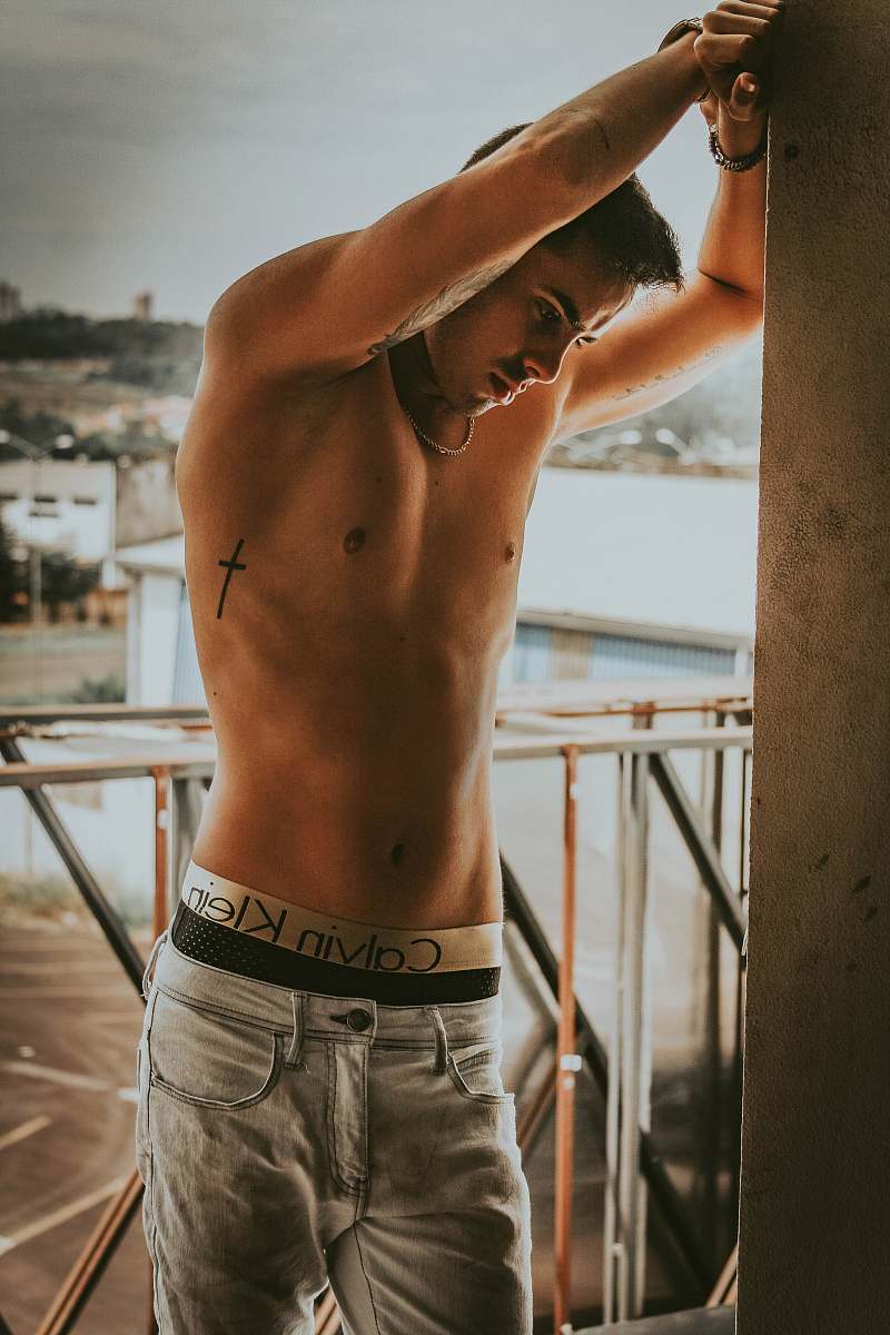 human topless man leaning against wall back