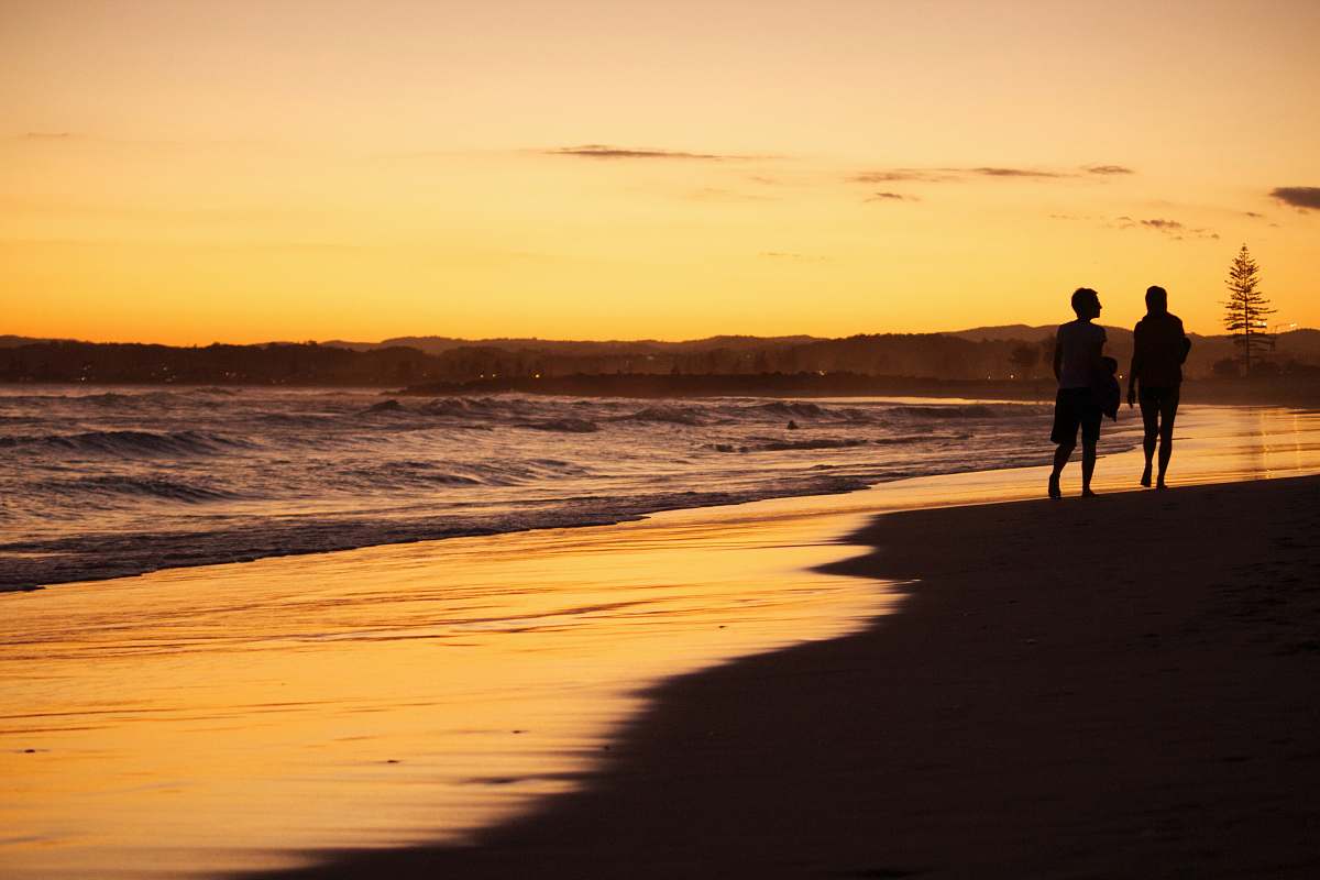 Experience the tranquility of nature as two individuals leisurely stroll along a picturesque beach. The scene captures the essence of human connection with the natural world, showcasing golden sands and gentle waves. Perfect for travel blogs, wellness articles, and nature-inspired content, this image evokes feelings of peace, relaxation, and the simple joys of life.