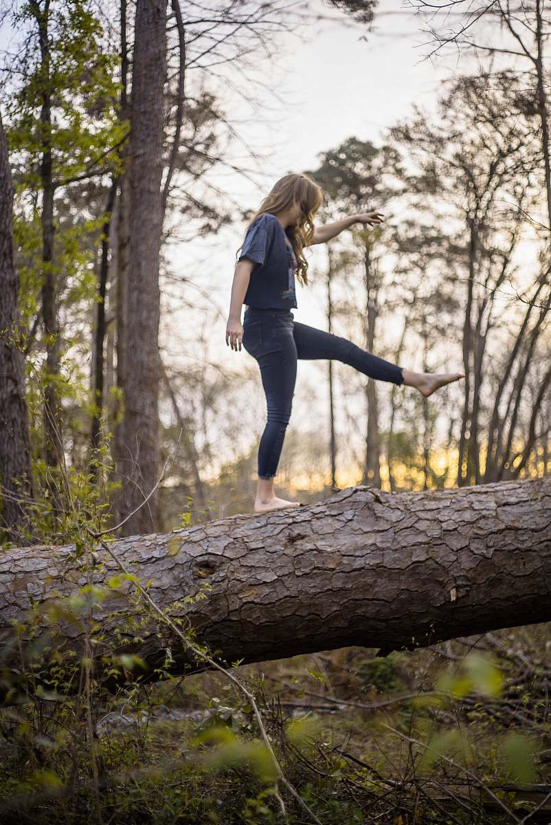 human woman balancing on log plant