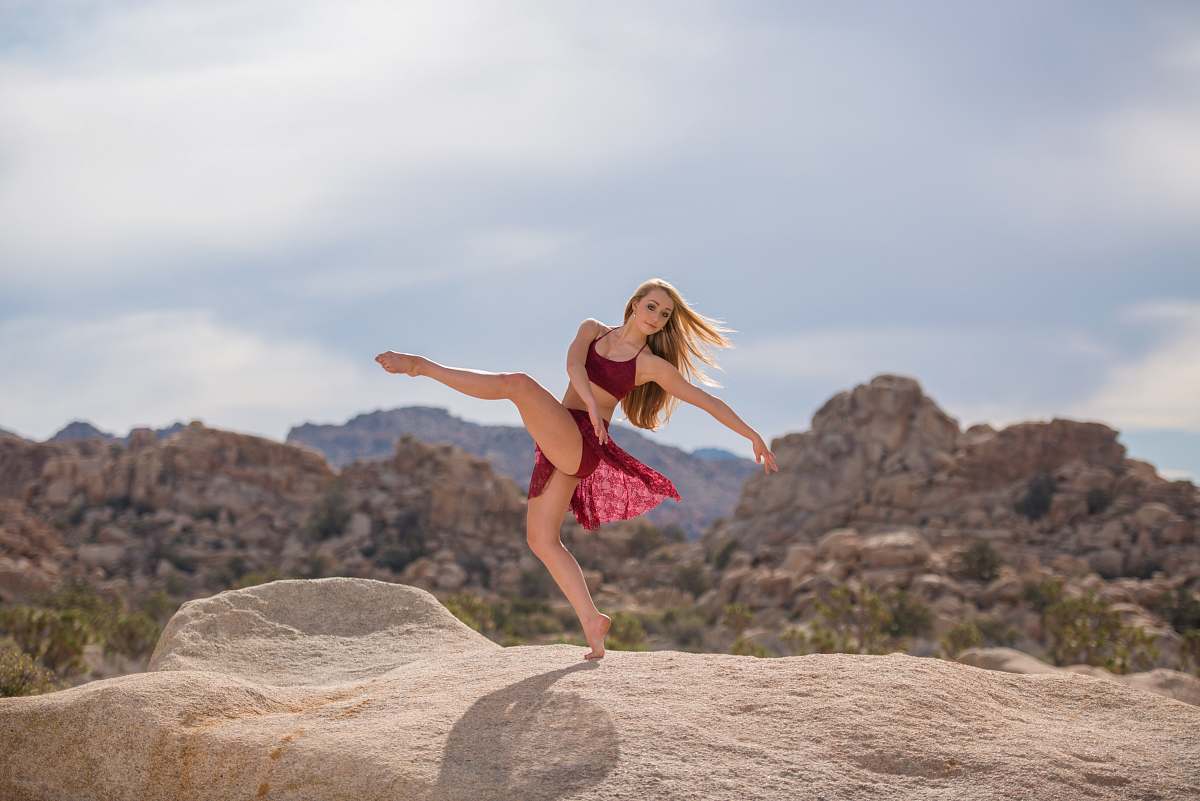 human woman dancing on brown hill during daytime woman