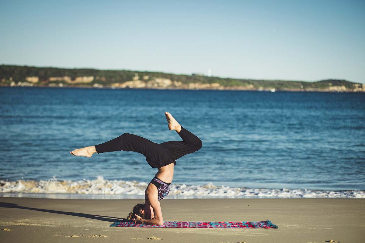 people woman doing yoga beside the seashore yoga