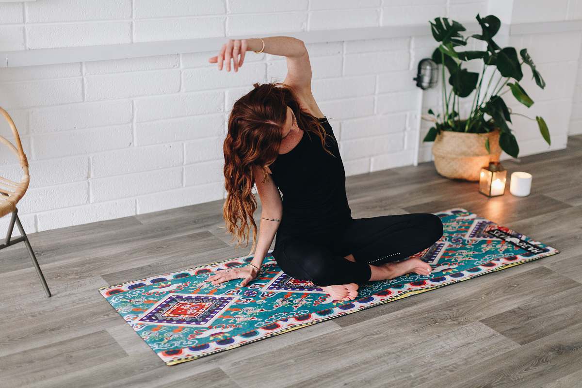 human woman doing yoga inside room furniture