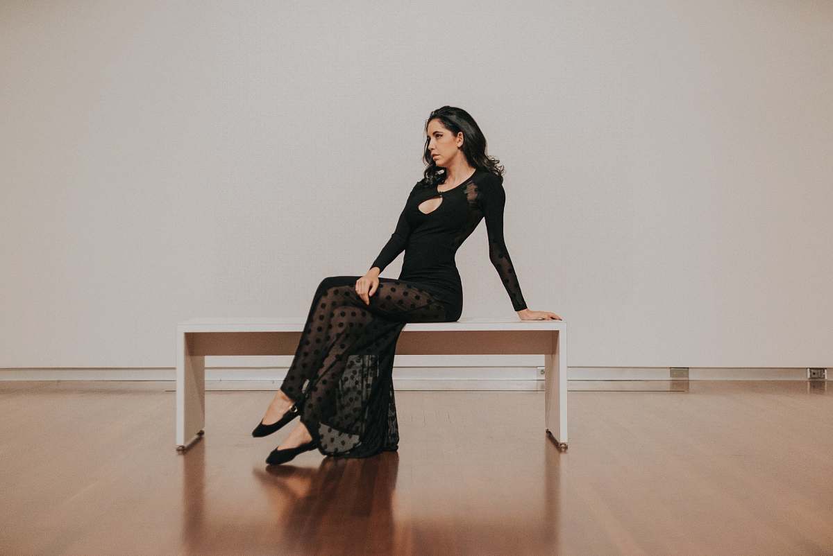 human woman in black dress sitting on bench wood