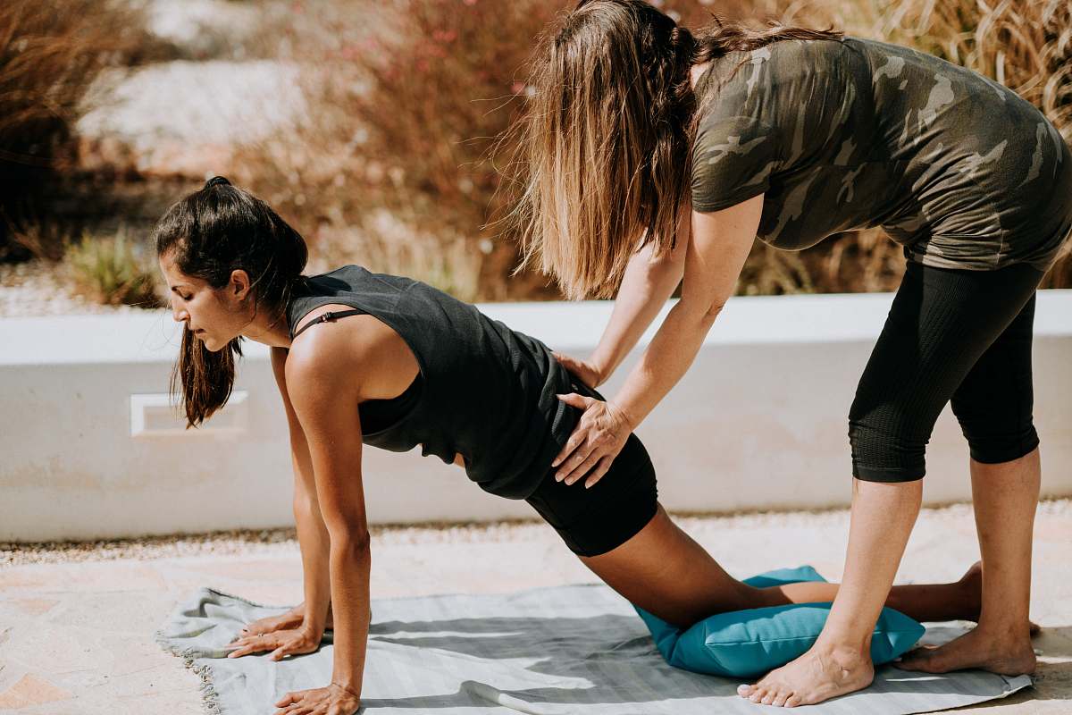 human woman in black tank top and black shorts kneeling on mat people