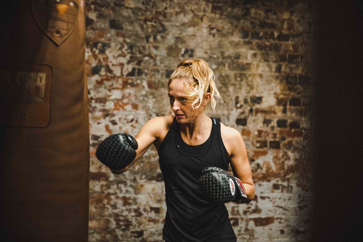 human woman in black tank top wearing boxing gloves sport