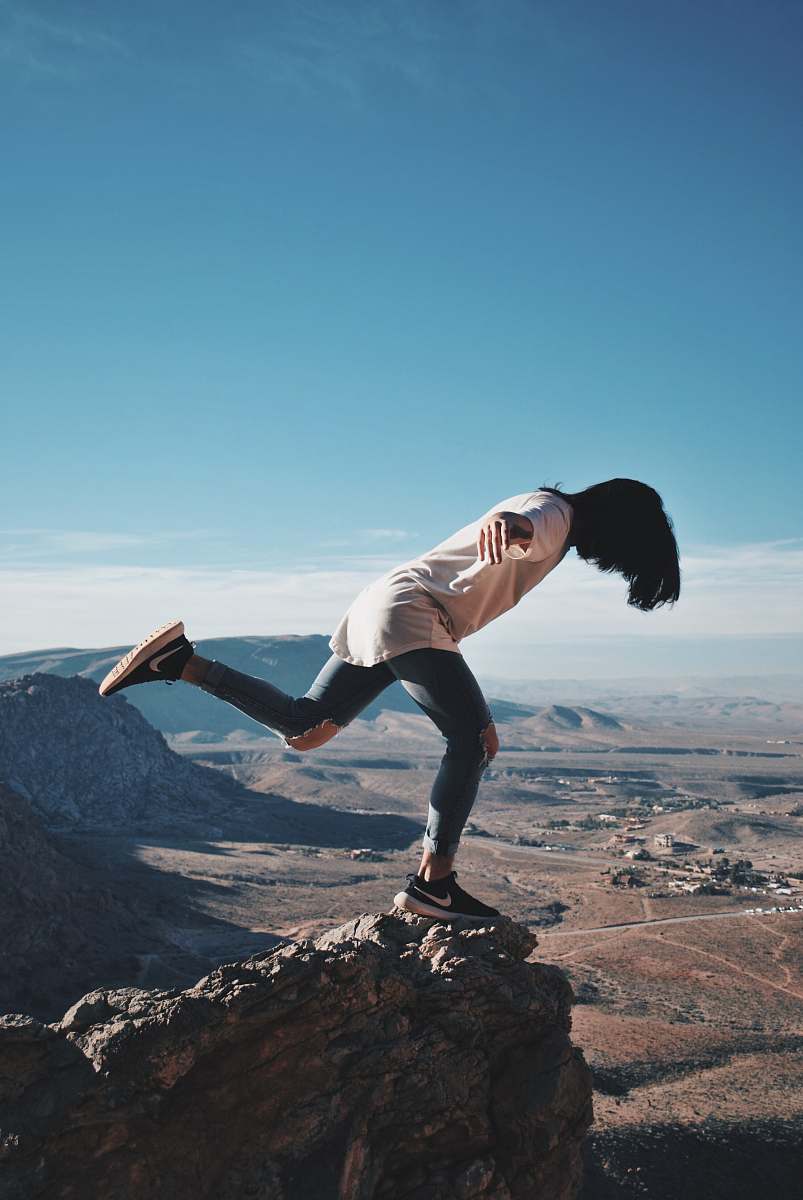 human woman in stands on mountain edge outdoors
