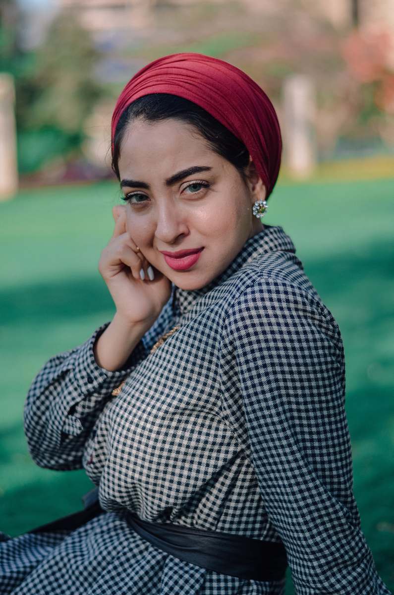 people woman in white and black gingham long-sleeved dress and red scarf human