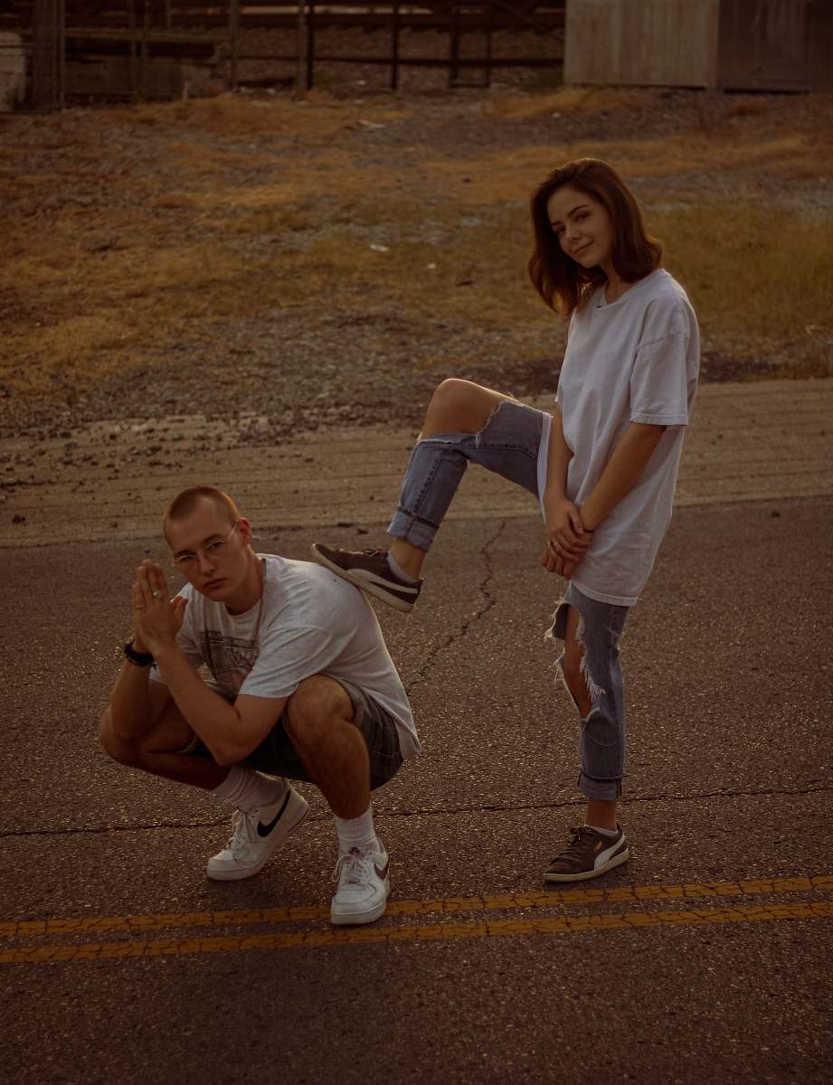 human woman in white stepping on crouching man's back apparel