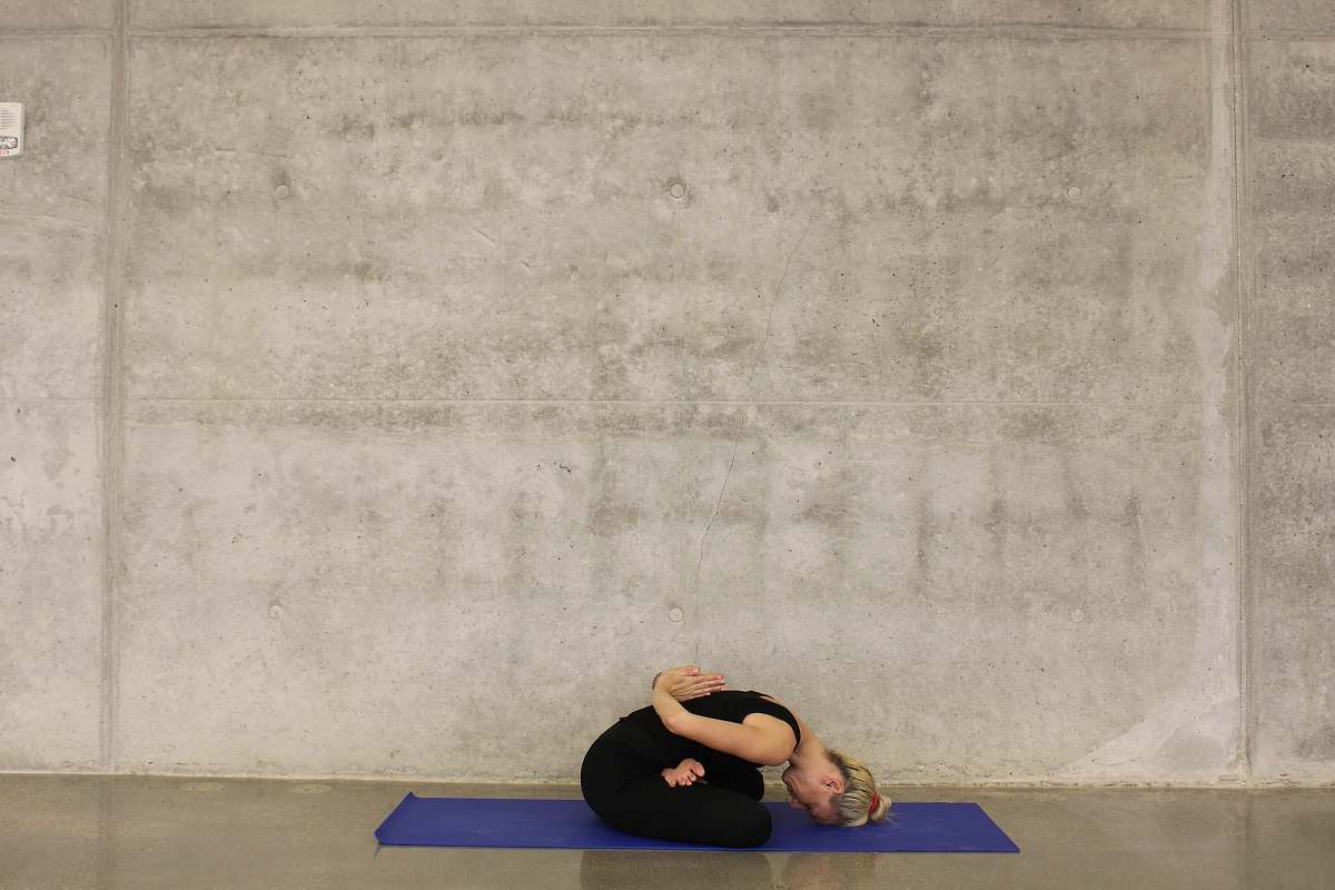 exercise woman sitting down on blue yoga mat sports