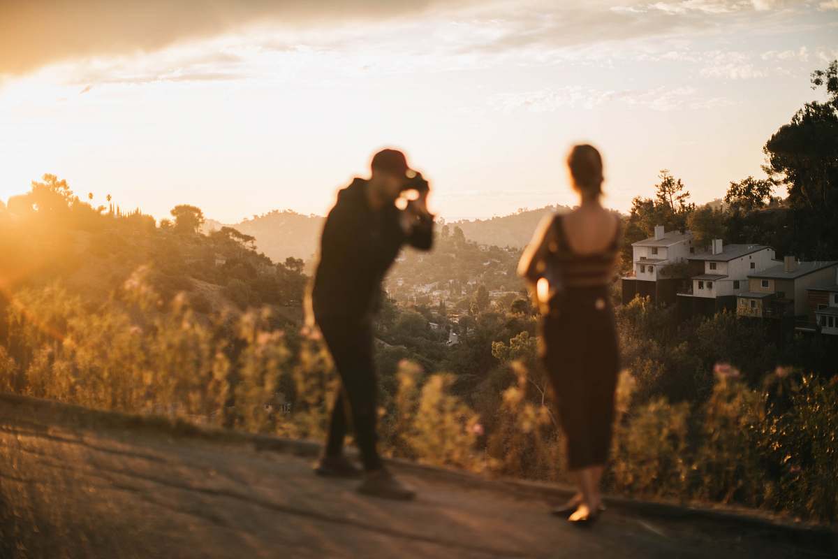 human woman standing beside man holding DSLR camera east los angeles