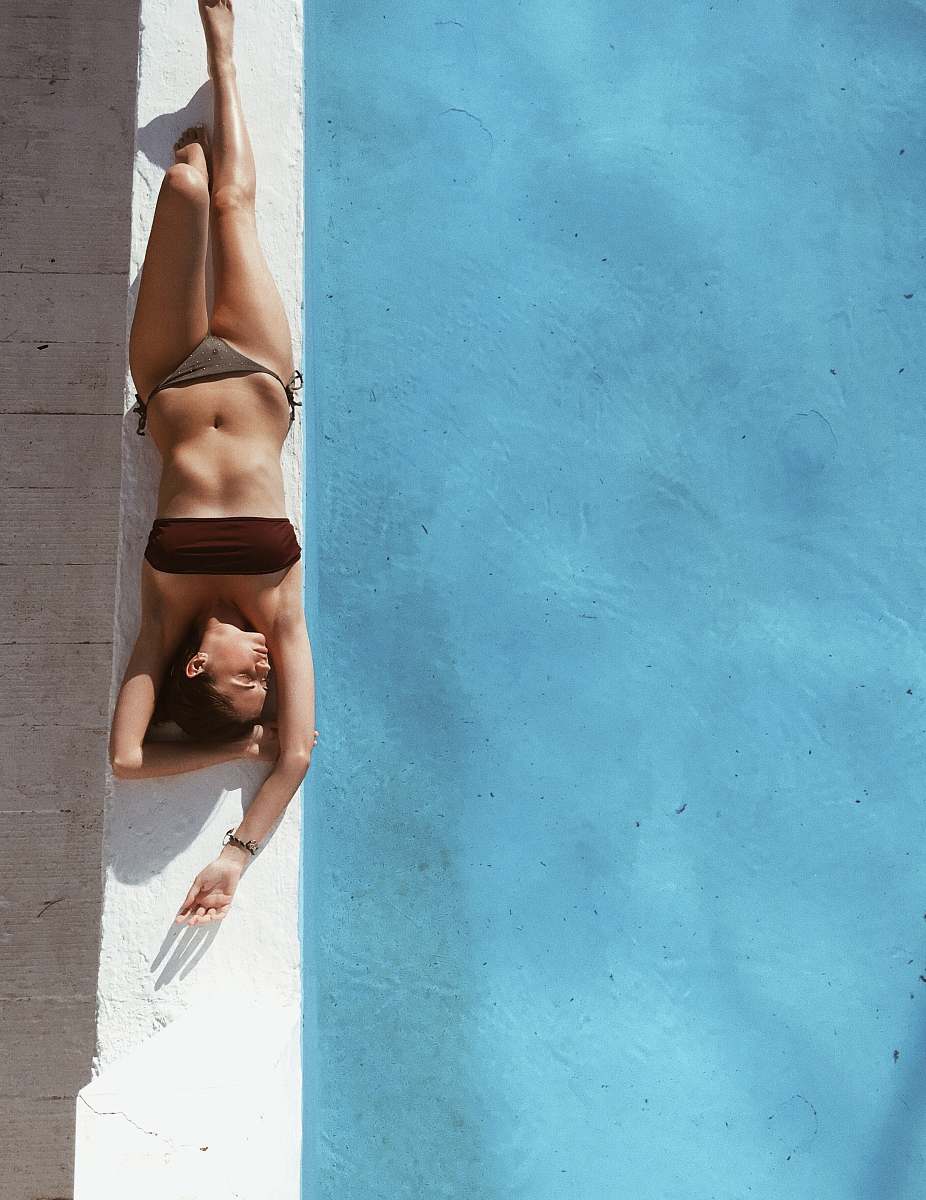 human woman sunbathing beside pool fitness
