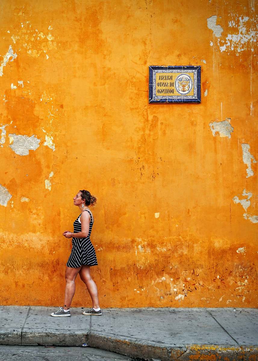people woman walking on sidewalk yellow