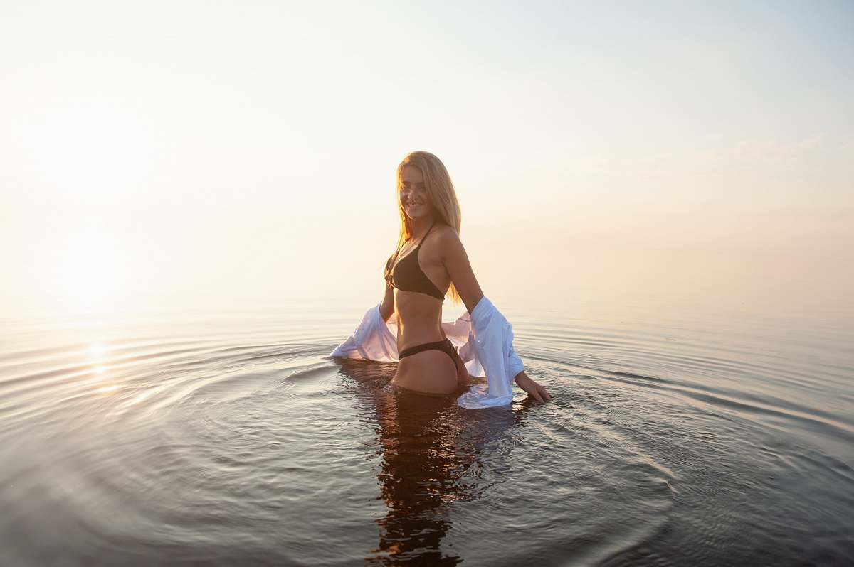 bikini woman wearing black bikini set standing in the middle of body of water swimwear