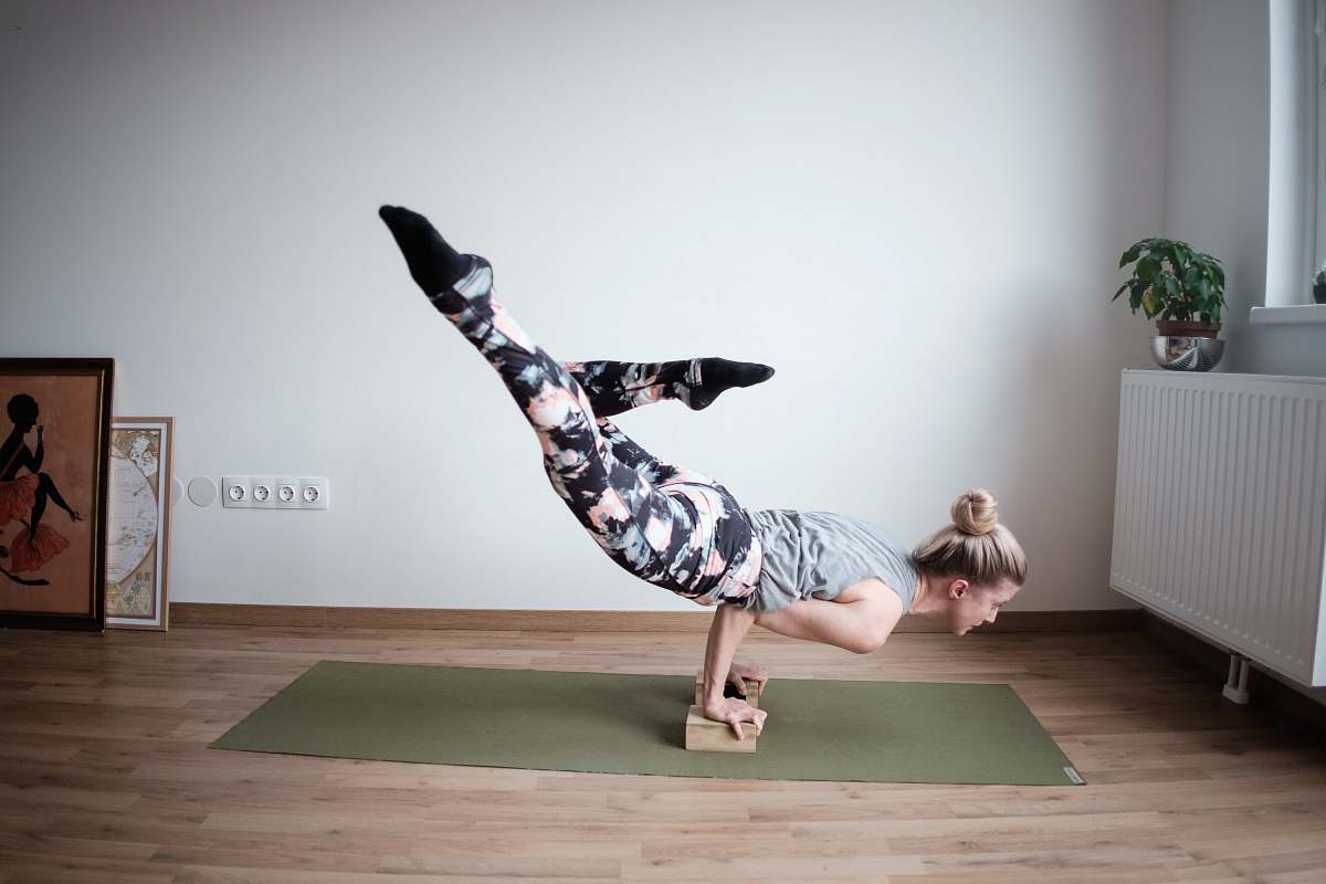 yoga woman balancing her body on olive-green mat dance pose
