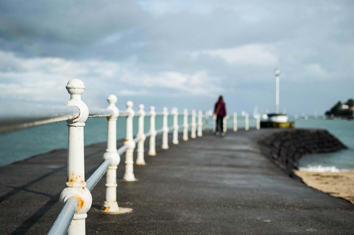ocean shallow focus photography of man near shore during daytime coast