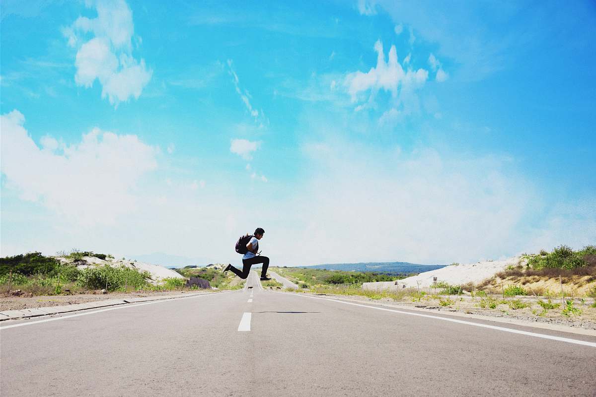blue man jumping on street during daytime sky