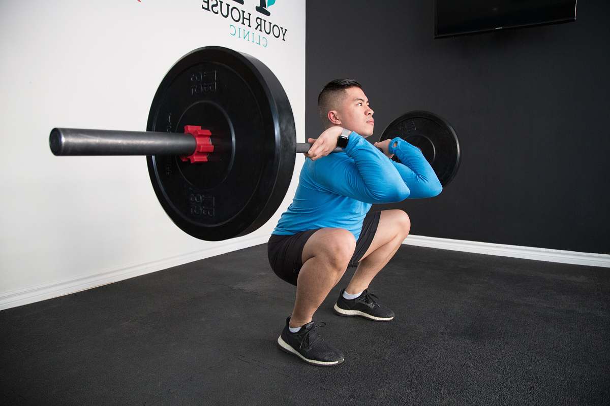 clothing man sitting and lifting black barbell apparel