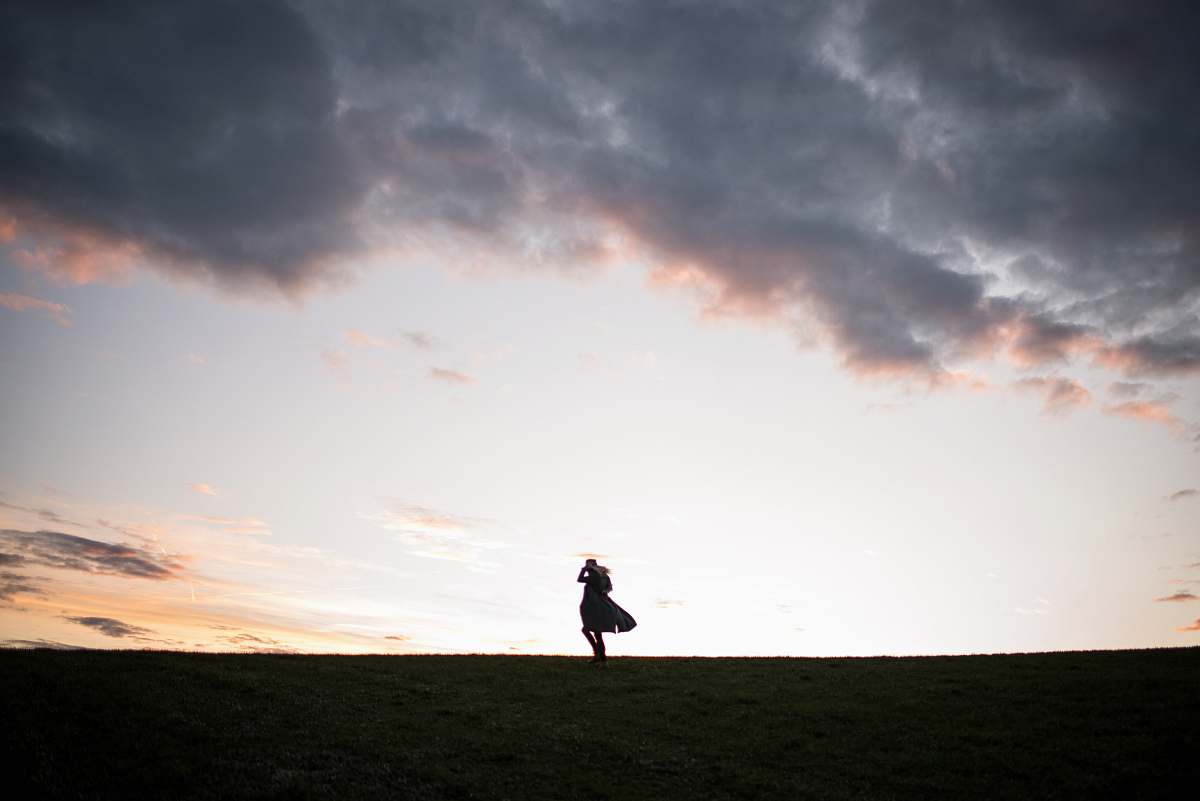 cloud silhouette of man standing on ground under cloudy sky landscape