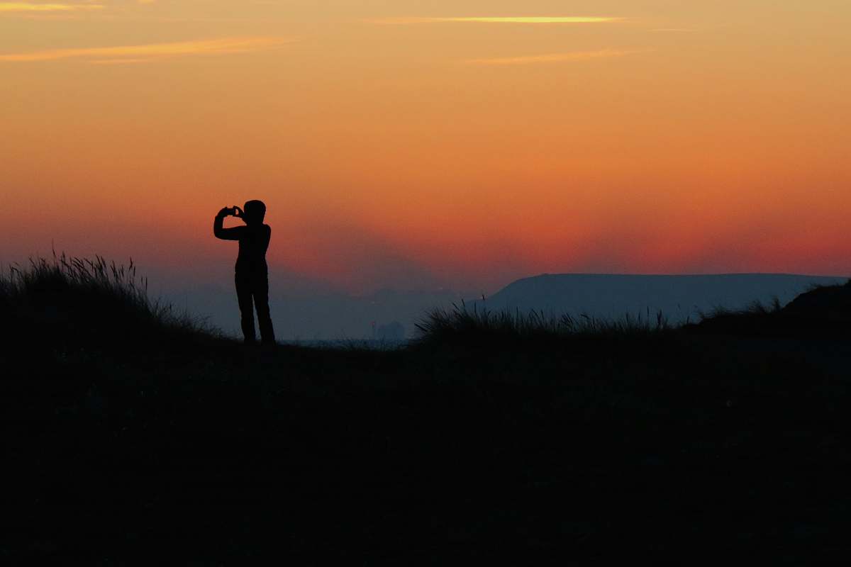 sunrise silhouette of person taking photo during sundown sunset