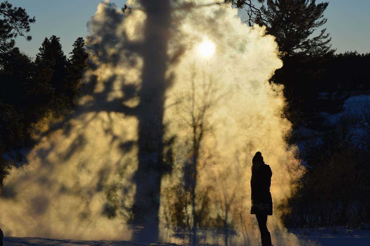 eruption person standing near trees geyser
