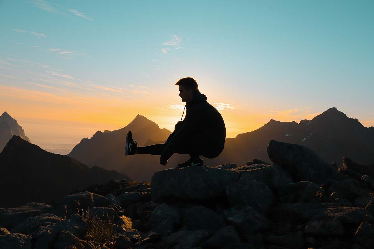 sunset silhouette on man on mountain silhouette