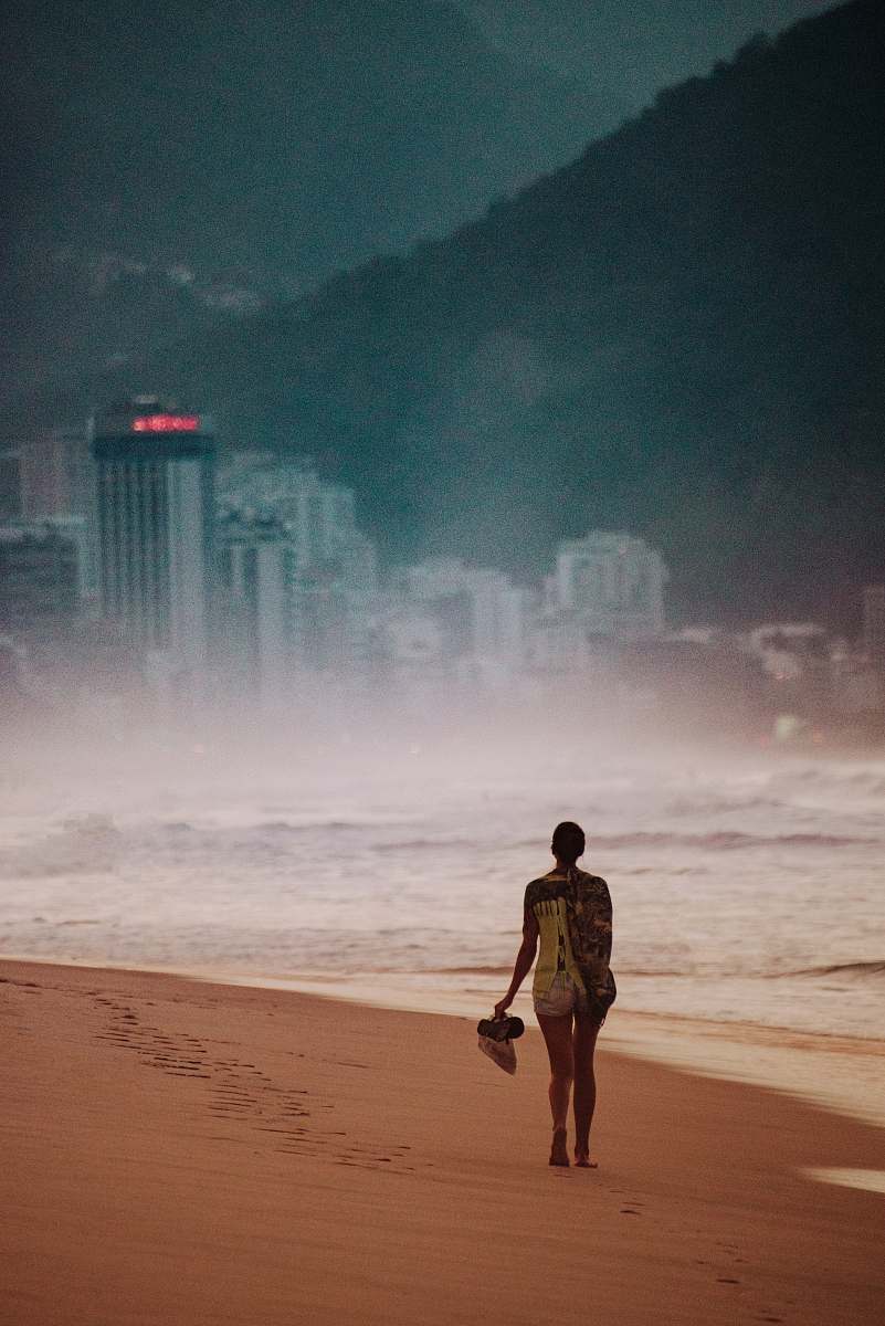 person girl walking on seashore across city building human