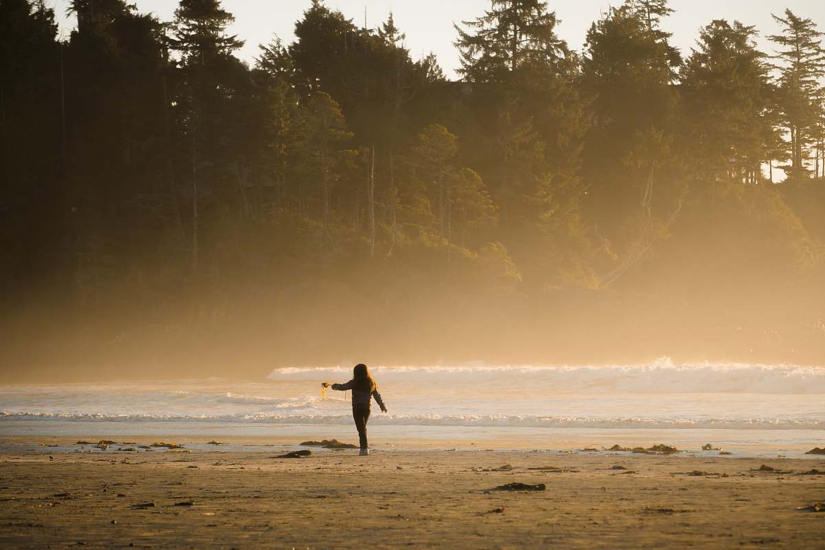 beach person playing with sand on seashore tofino