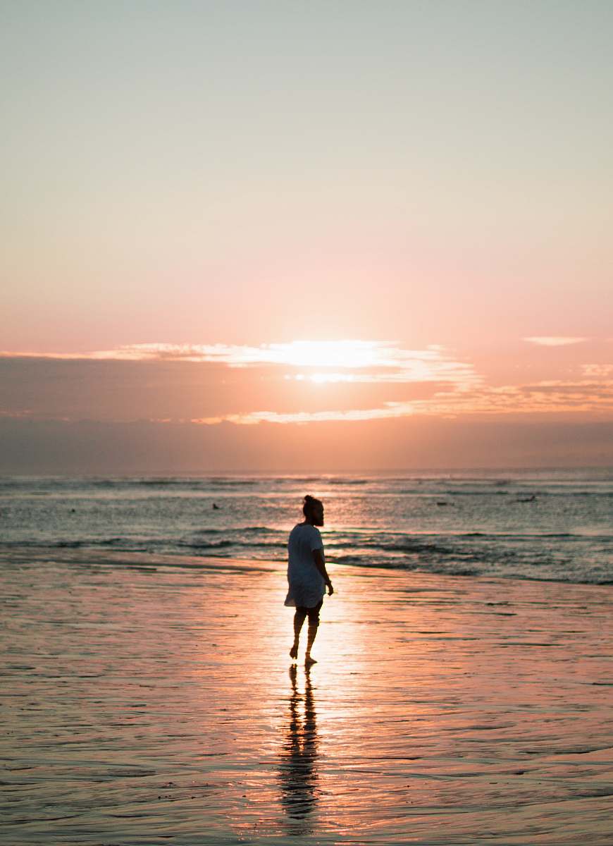 ocean person walking on seashore during golden hour sea