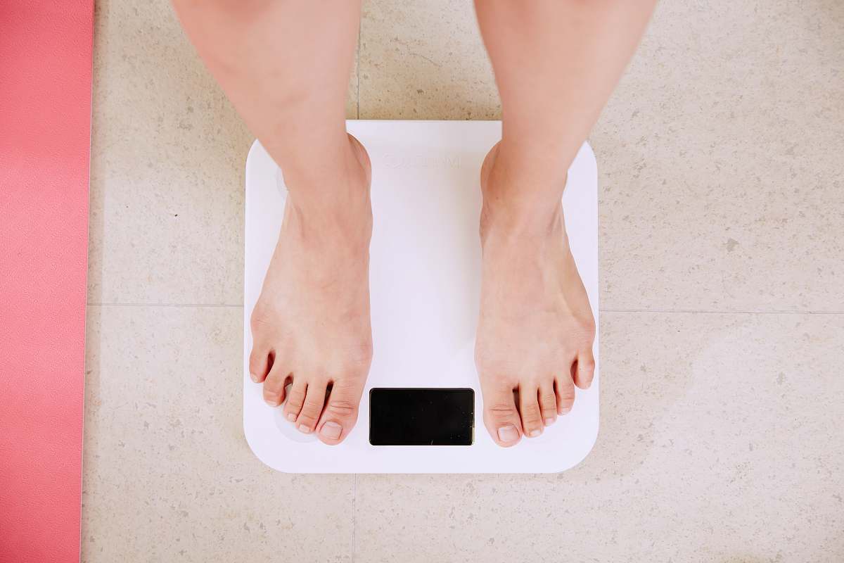 health person standing on white digital bathroom scale diet