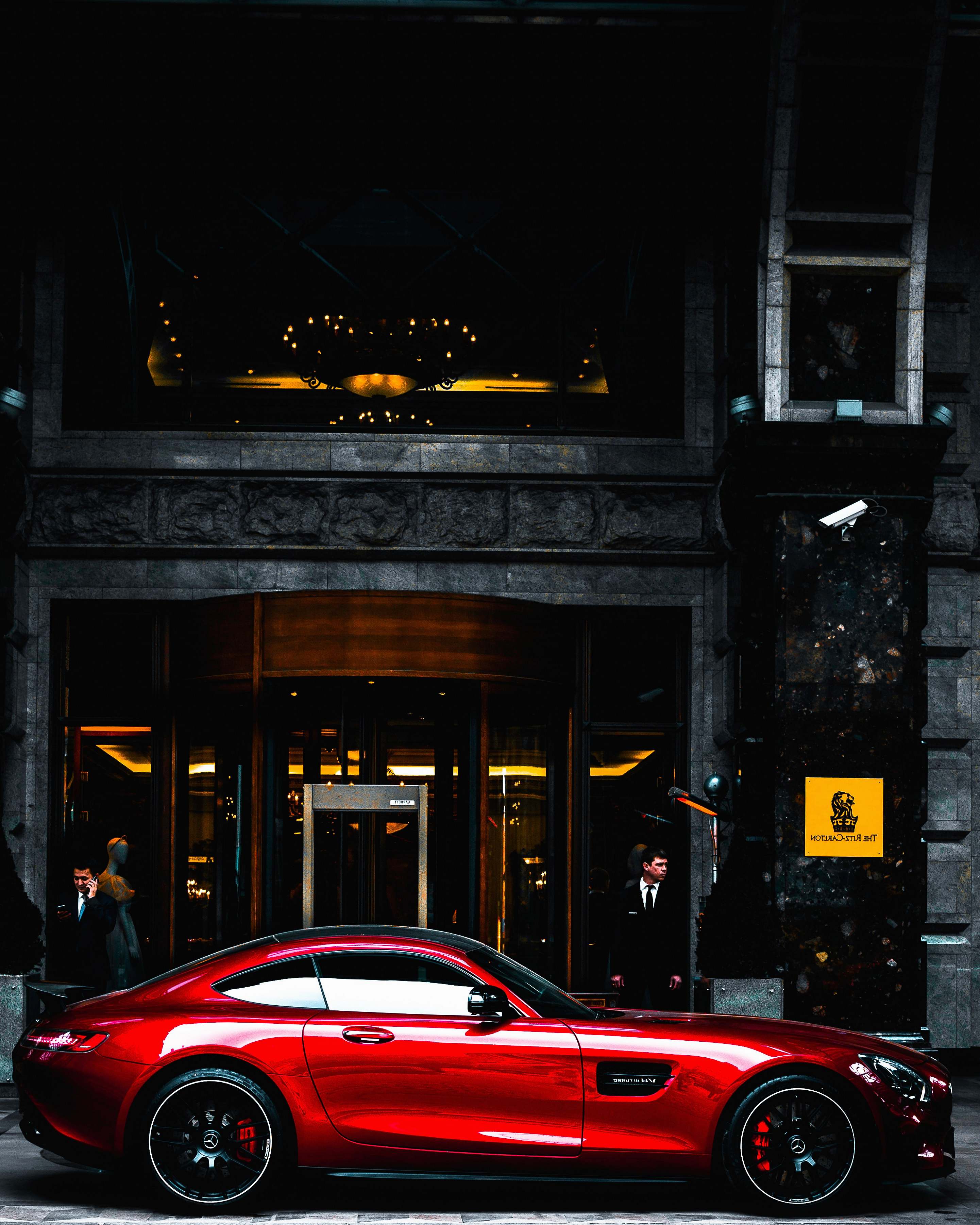 Automobile Red Coupe Parked In Front Of Black And Gray Building During ...