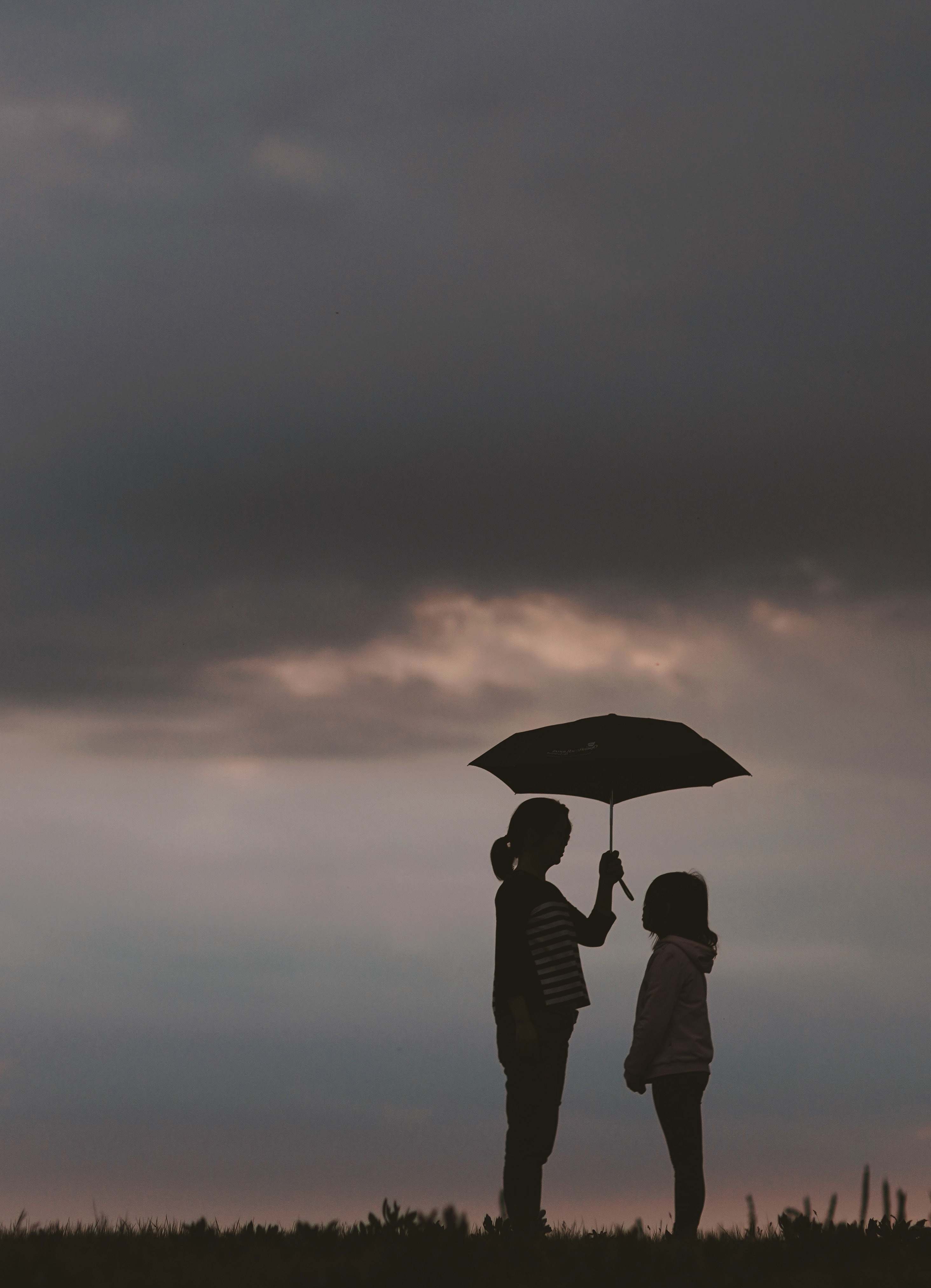 Human Silhouette Of Woman Holding Umbrella Standing In Front Of Girl On ...