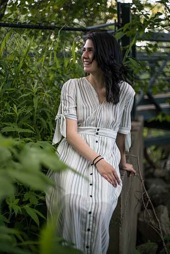 clothing smiling woman wearing white and grey striped dress evening dress