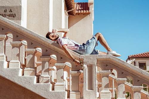 handrail man lying on gray staircase asleep