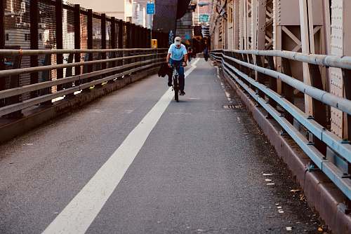 human man riding bicycle in bridge person